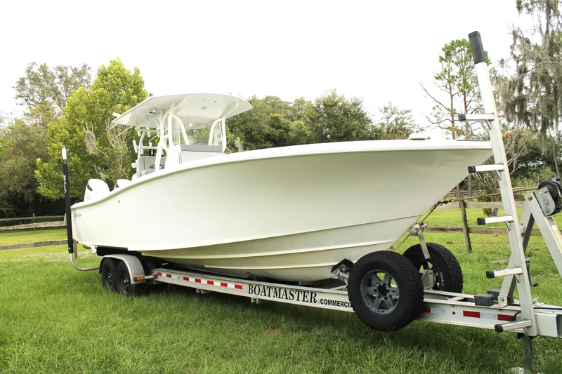  Yacht Photos Pics 2005 Yellowfin 31 Open boat on trailer, parked on grass.