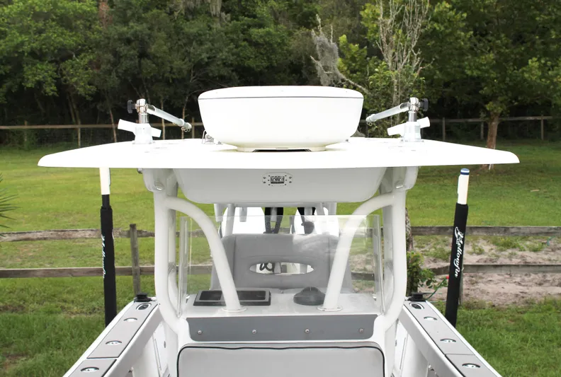  Yacht Photos Pics 2005 Yellowfin 31 Open boat with T-top and rod holders, set in a lush green background.