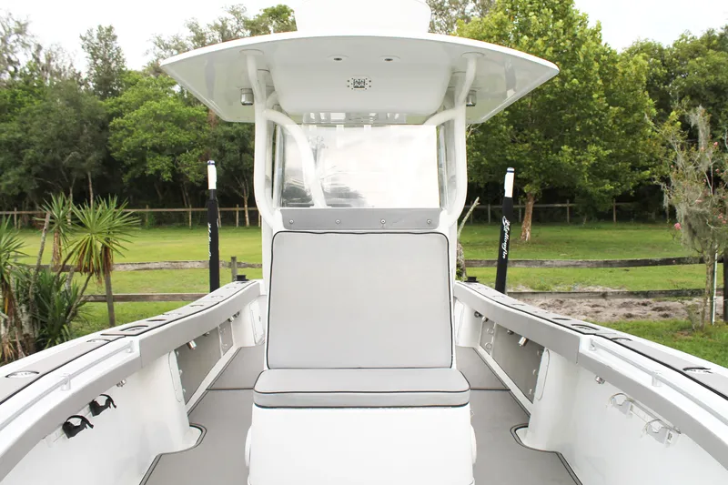  Yacht Photos Pics 2005 Yellowfin 31 Open boat interior with seating and lush greenery background.