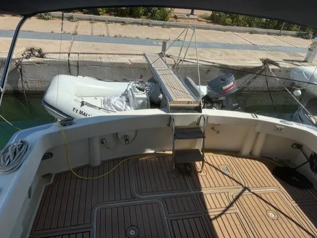  Yacht Photos Pics 1989 Hatteras 52 yacht deck with wooden flooring and docked inflatable boat.