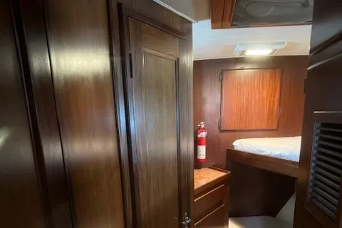  Yacht Photos Pics Interior of 1989 Hatteras 52 yacht cabin with wooden finish and fire extinguisher.