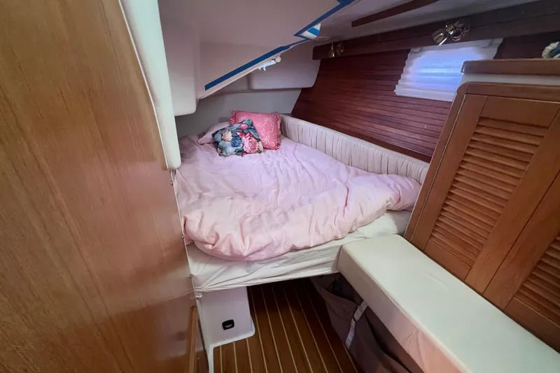  Yacht Photos Pics Cozy cabin interior of 2007 Catalina 42 MkII with pink bedding and wooden accents.