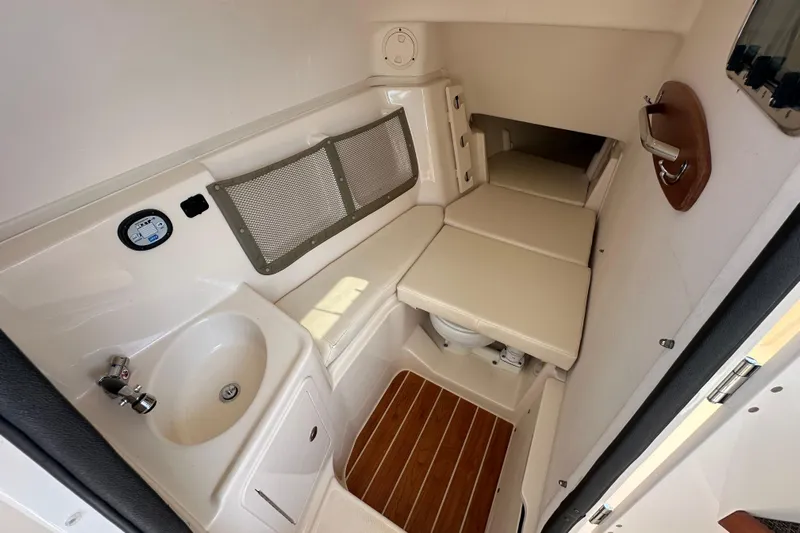  Yacht Photos Pics 2016 Grady-White Freedom 307 cabin interior with sink, seating, and wooden flooring.