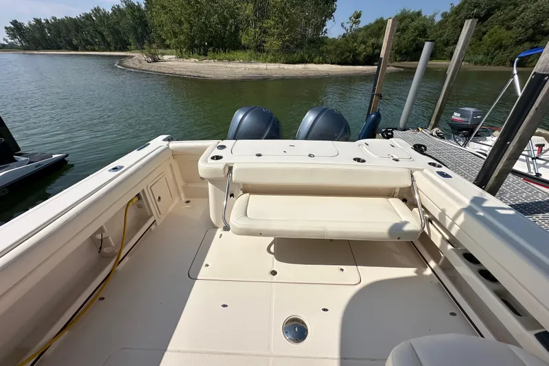  Yacht Photos Pics 2016 Grady-White Freedom 307 boat interior with dual engines, docked by a scenic shoreline.