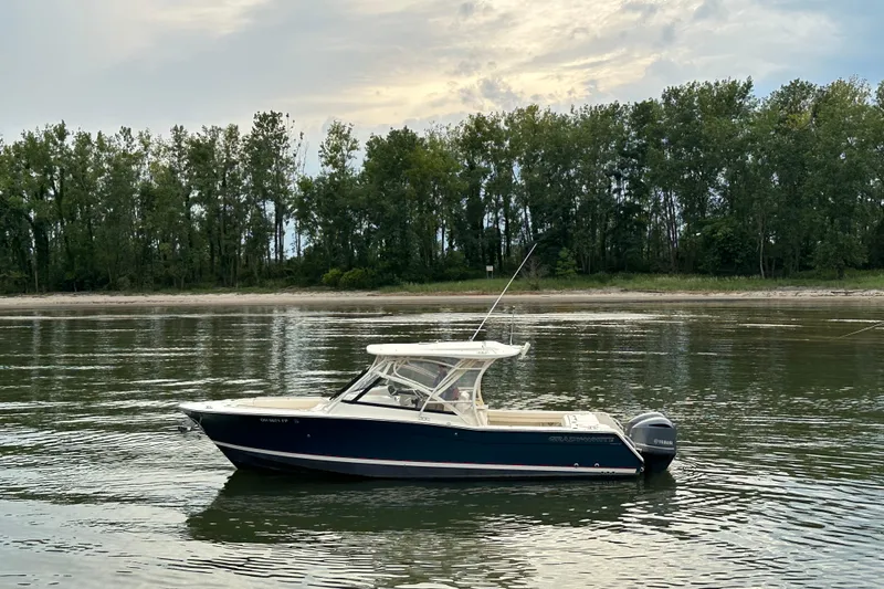  Yacht Photos Pics 2016 Grady-White Freedom 307 boat on calm water with tree-lined shore.