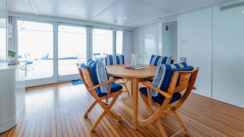 Focus Yacht Photos Pics Luxurious 2002 North American Tri-Deck Motor Yacht interior with elegant dining area and wooden flooring.