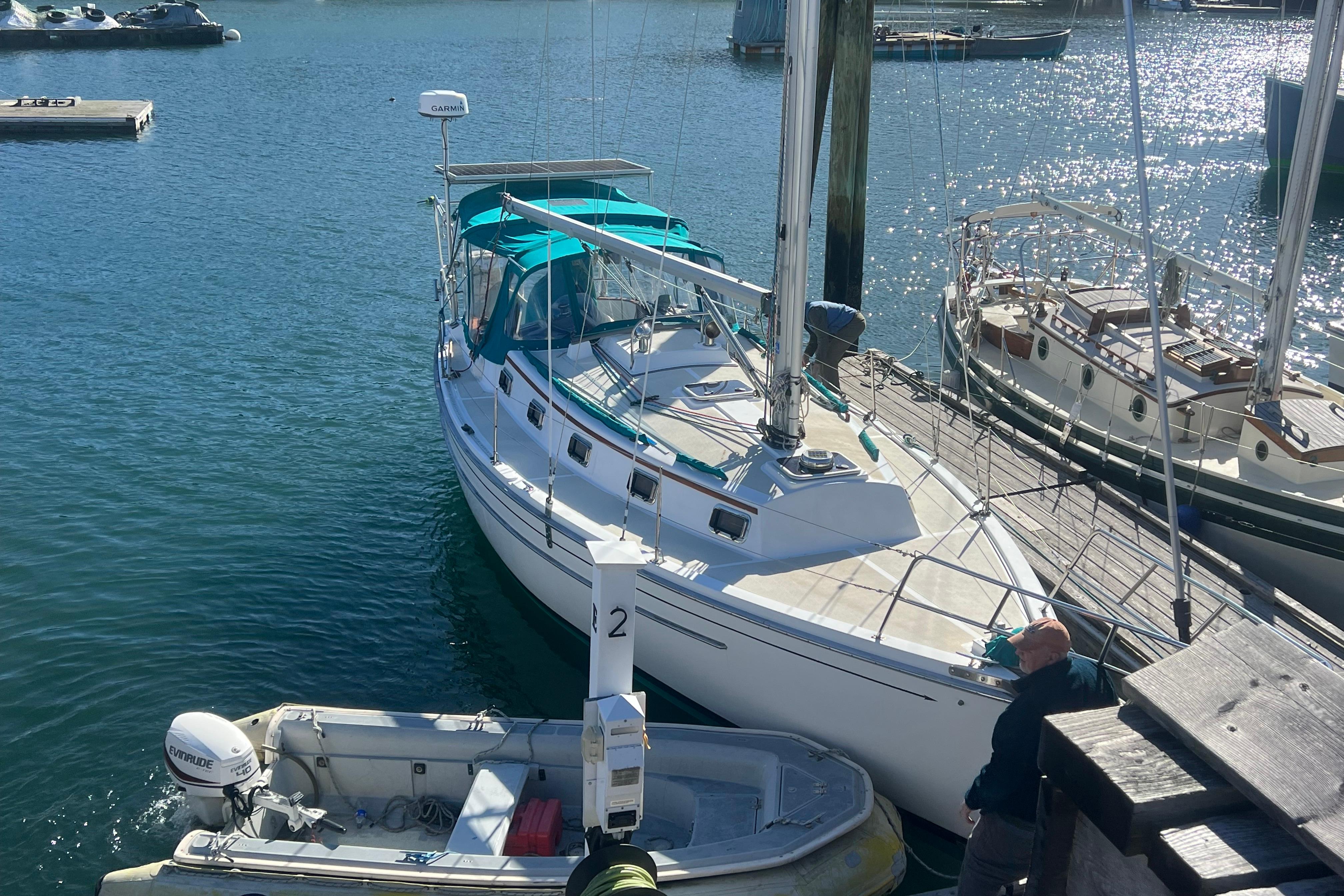 1993 Compac Sloop docked at marina, with clear blue water and nearby boats.