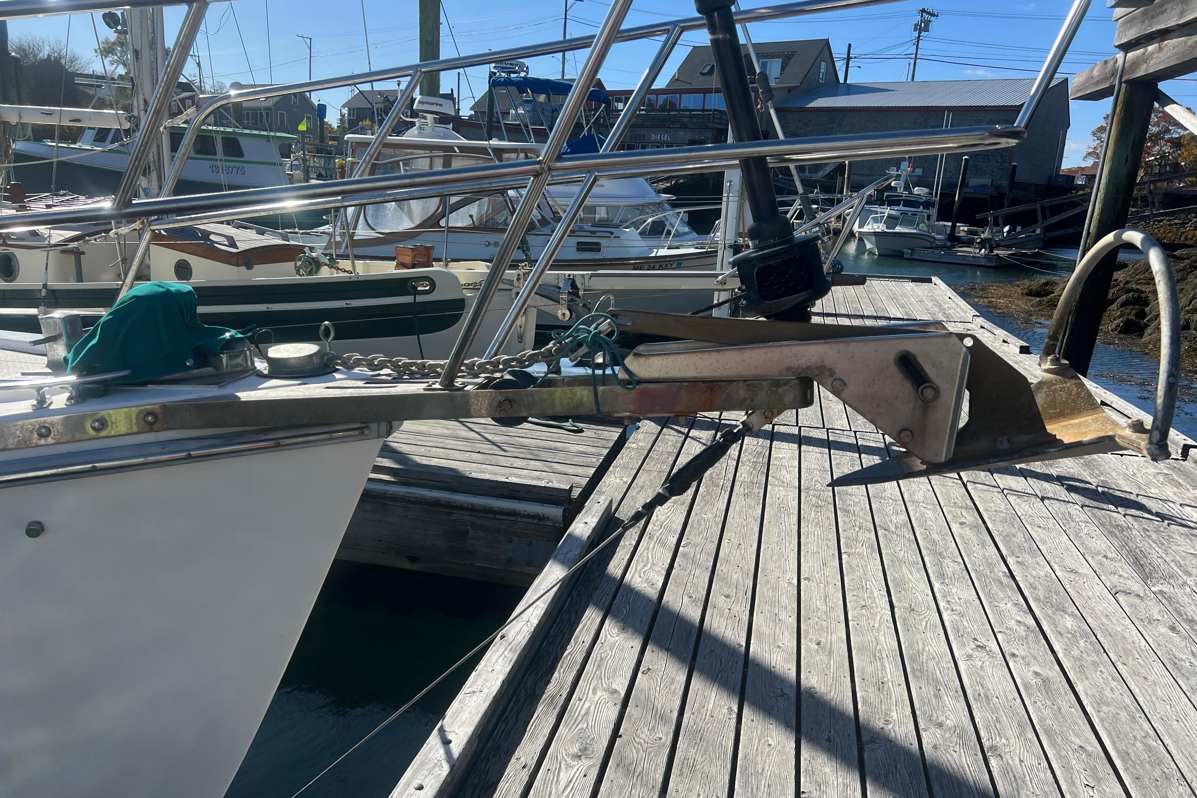 1993 Compac Sloop docked with anchor and chain on wooden pier.
