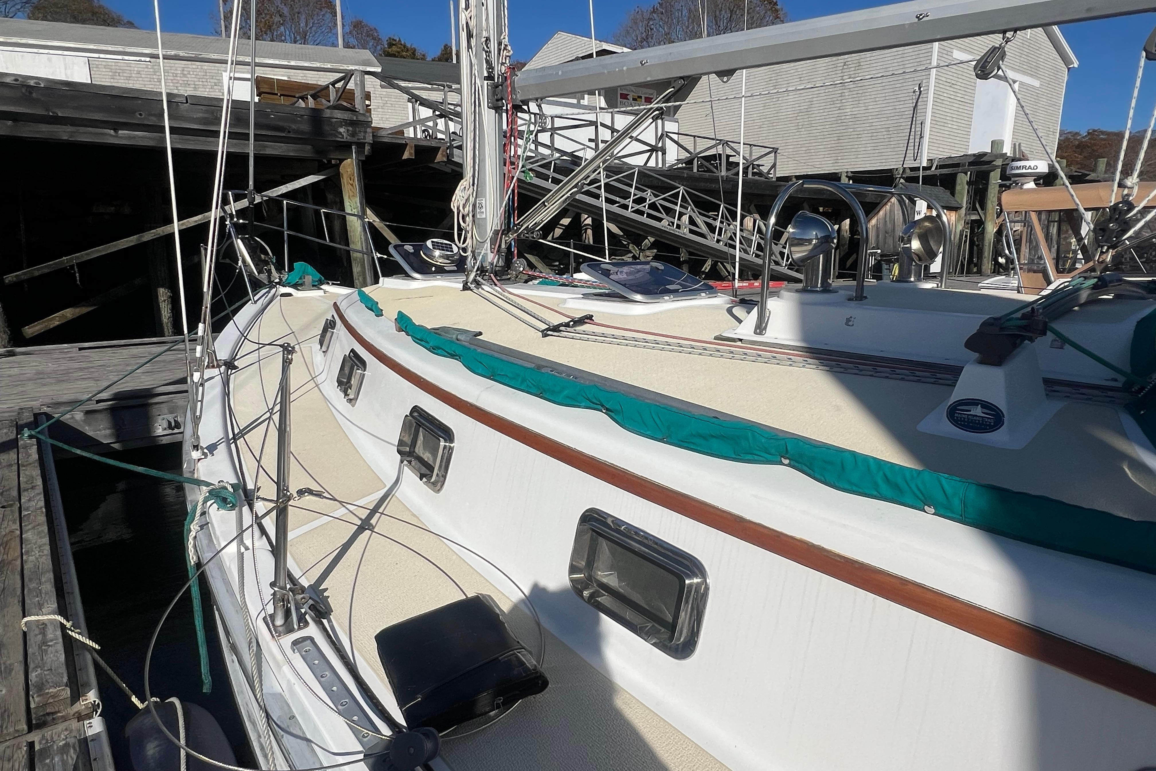 1993 Compac Sloop sailboat docked, featuring a clean deck and vibrant green trim.