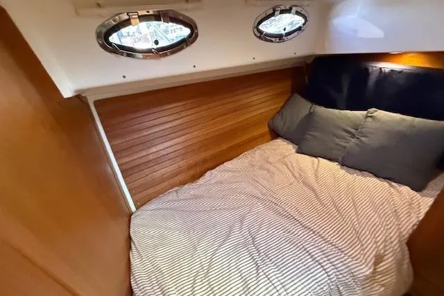 Someday Soon Yacht Photos Pics Cozy cabin interior of 2015 Back Cove 37 yacht with wood paneling and portholes.