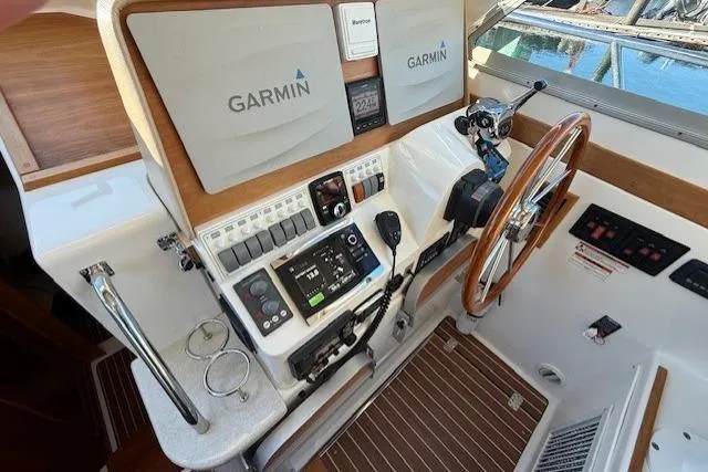 Someday Soon Yacht Photos Pics Helm station of 2015 Back Cove 37 with Garmin navigation equipment and wooden steering wheel.