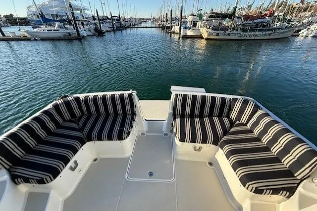 Someday Soon Yacht Photos Pics 2015 Back Cove 37 yacht with striped seating, docked in a marina.