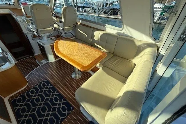 Someday Soon Yacht Photos Pics Interior of 2015 Back Cove 37 yacht with seating and table, docked at marina.