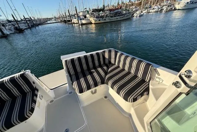 Someday Soon Yacht Photos Pics 2015 Back Cove 37 yacht with striped seating, docked in a marina.