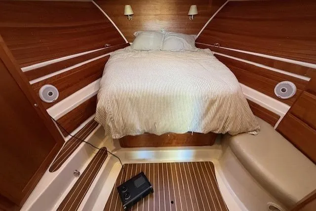 Someday Soon Yacht Photos Pics Cozy cabin interior of 2015 Back Cove 37 boat with wooden accents and bed.