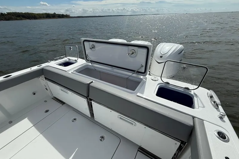  Yacht Photos Pics 2026 Everglades 375 Center Console boat with open storage compartments on a calm sea.