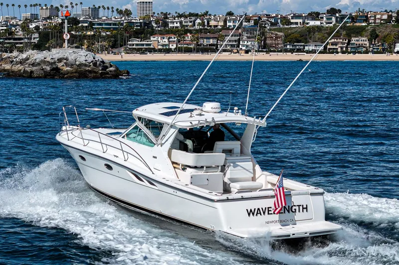 Wave Length Yacht Photos Pics 2001 Tiara Yachts 3500 Open cruising near a coastal cityscape.