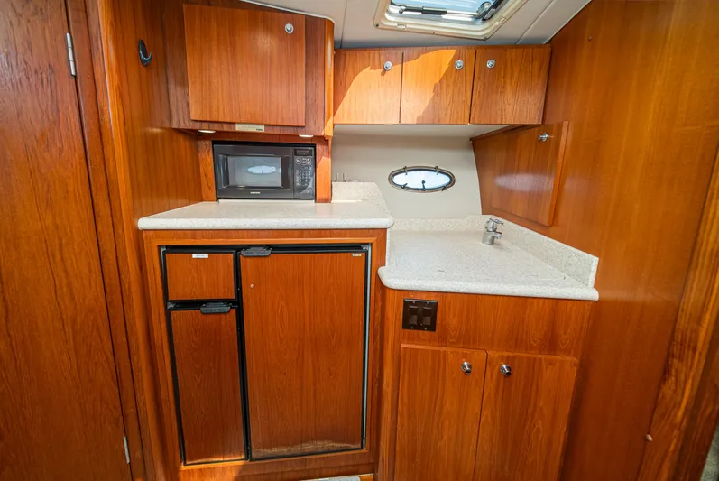 Wave Length Yacht Photos Pics 2001 Tiara Yachts 3500 Open galley with wood cabinetry, microwave, and compact fridge.