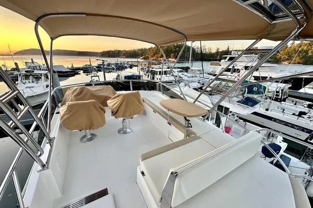 Topcat Yacht Photos Pics Aspen C120 2022 boat deck at marina during sunset, featuring covered seating and scenic view.