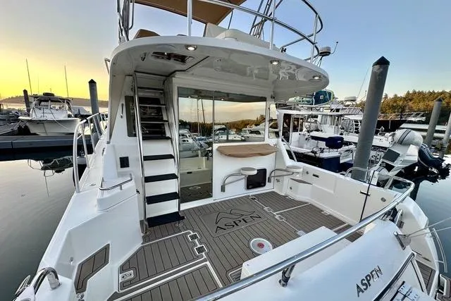 Topcat Yacht Photos Pics 2022 Aspen C120 yacht at marina, featuring spacious deck and modern design.