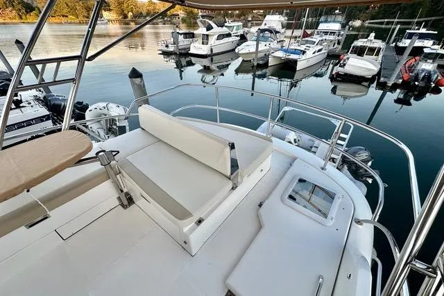 Topcat Yacht Photos Pics 2022 Aspen C120 boat deck with seating, overlooking marina with multiple boats docked.