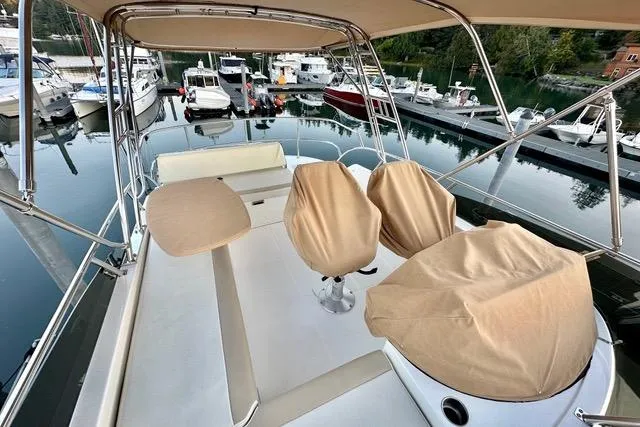 Topcat Yacht Photos Pics 2022 Aspen C120 boat interior with covered seats and table at marina.