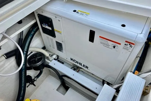 Topcat Yacht Photos Pics Kohler generator in 2022 Aspen C120 boat engine compartment, showing hoses and control panel.