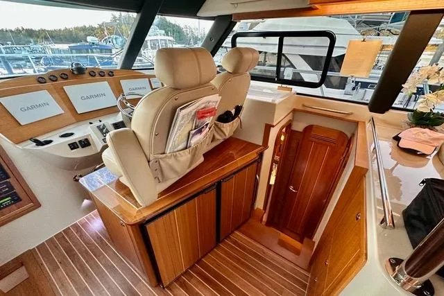 Topcat Yacht Photos Pics Interior of 2022 Aspen C120 boat with helm, navigation screens, and wooden cabinetry.