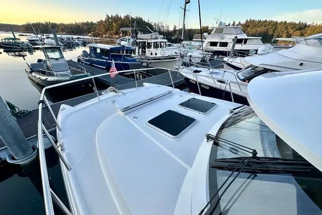 Topcat Yacht Photos Pics 2022 Aspen C120 boat docked among other vessels in a scenic marina.