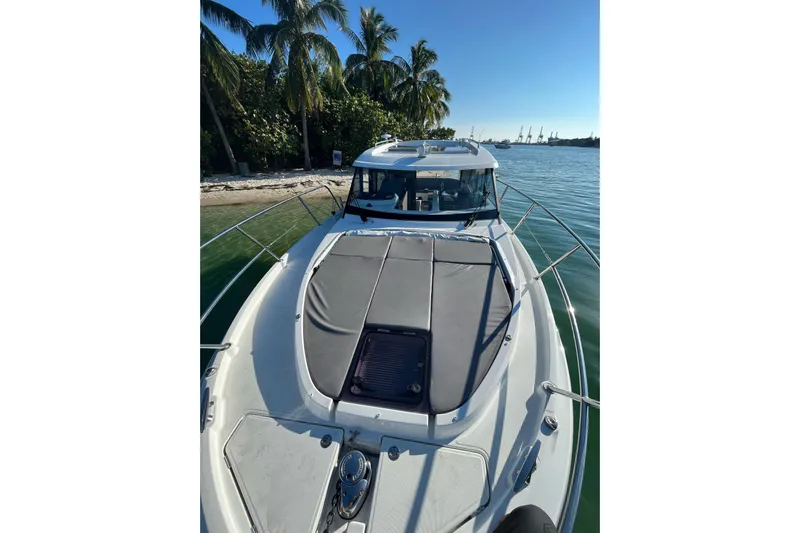 Seawalkin Yacht Photos Pics 2022 Beneteau Antares 11 boat docked near palm trees and calm waters.