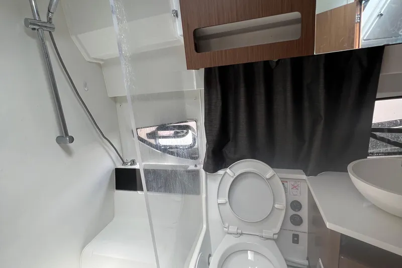 Seawalkin Yacht Photos Pics 2022 Beneteau Antares 11 bathroom with shower, toilet, and modern fixtures.