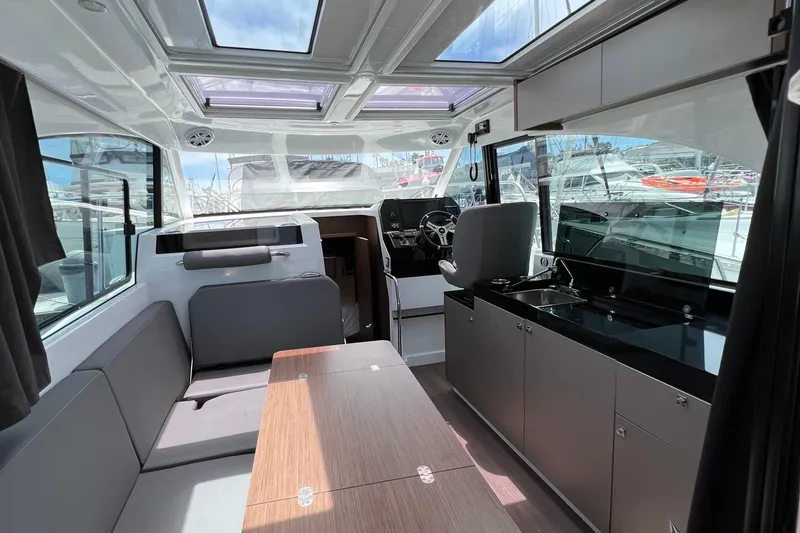 Seawalkin Yacht Photos Pics Interior of 2022 Beneteau Antares 11 boat with modern seating and kitchen area.