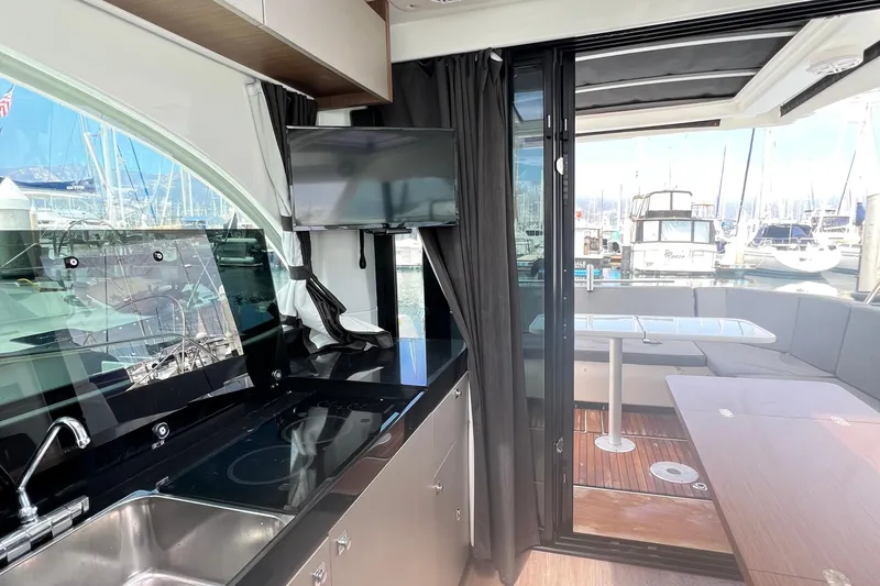 Seawalkin Yacht Photos Pics Interior view of 2022 Beneteau Antares 11 yacht with kitchen and outdoor seating area.