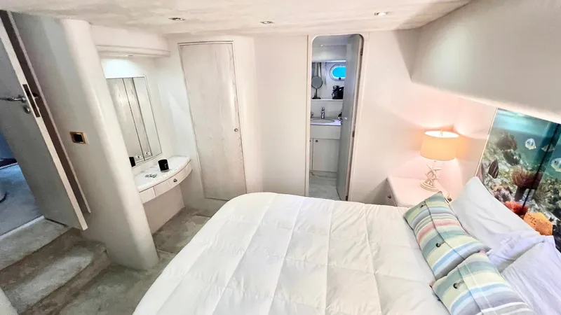  Yacht Photos Pics Luxurious Neptunus 58 Flybridge 1995 yacht bedroom with ensuite bathroom and cozy decor.