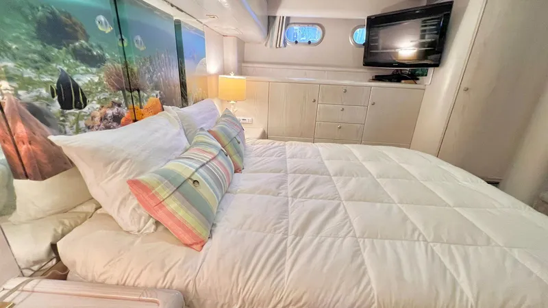  Yacht Photos Pics Luxurious bedroom in 1995 Neptunus 58 Flybridge yacht with ocean-themed decor.