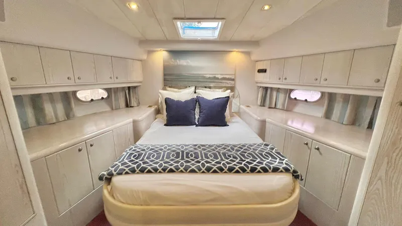  Yacht Photos Pics Luxurious bedroom in 1995 Neptunus 58 Flybridge yacht with elegant decor and ample storage.