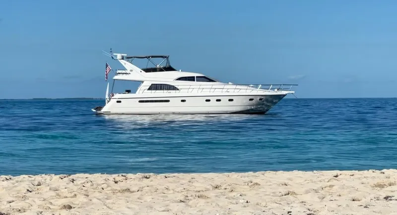  Yacht Photos Pics 1995 Neptunus 58 Flybridge yacht on calm ocean near sandy beach.