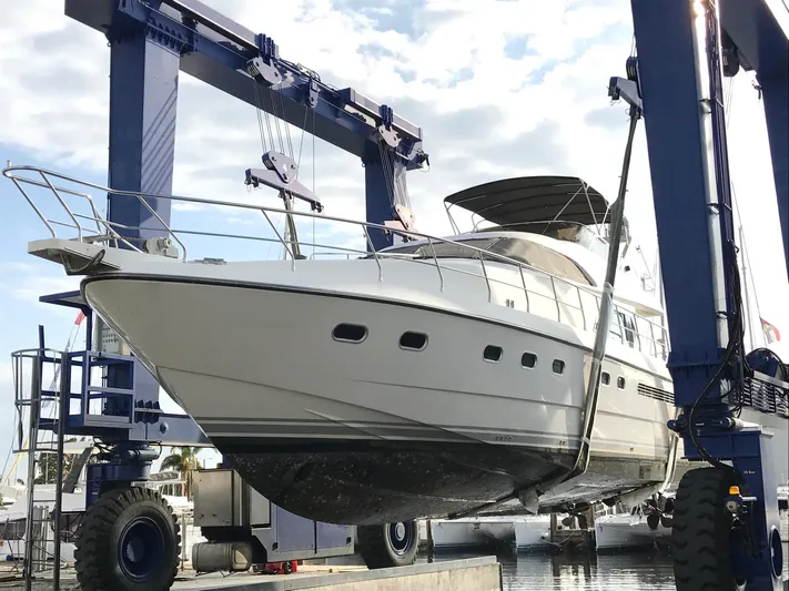  Yacht Photos Pics 1995 Neptunus 58 Flybridge yacht in dry dock, supported by a large boat lift.