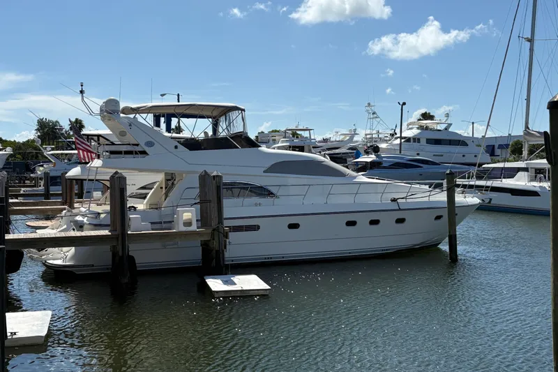  Yacht Photos Pics 1995 Neptunus 58 Flybridge yacht docked at marina under clear blue sky.