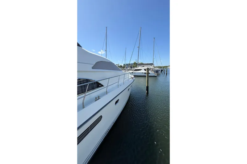  Yacht Photos Pics Neptunus 58 Flybridge yacht docked at marina, clear blue sky, 1995 model.