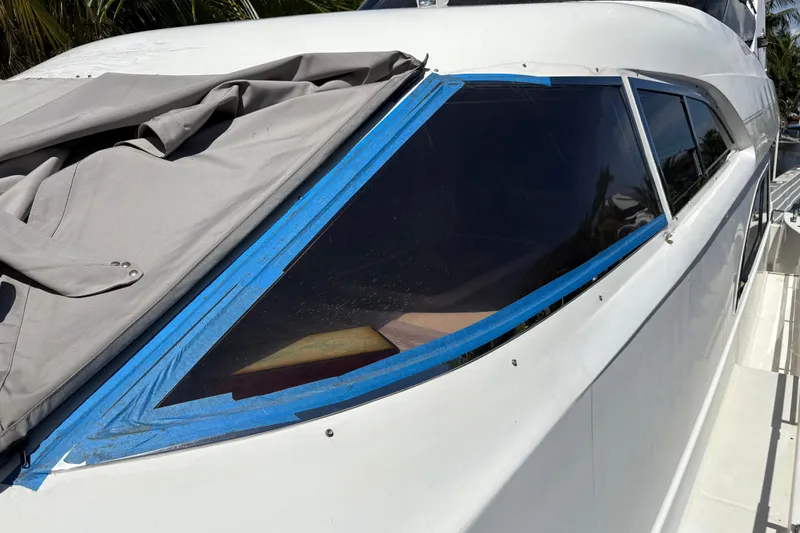  Yacht Photos Pics 1995 Neptunus 58 Flybridge yacht with covered windows and blue tape detailing.