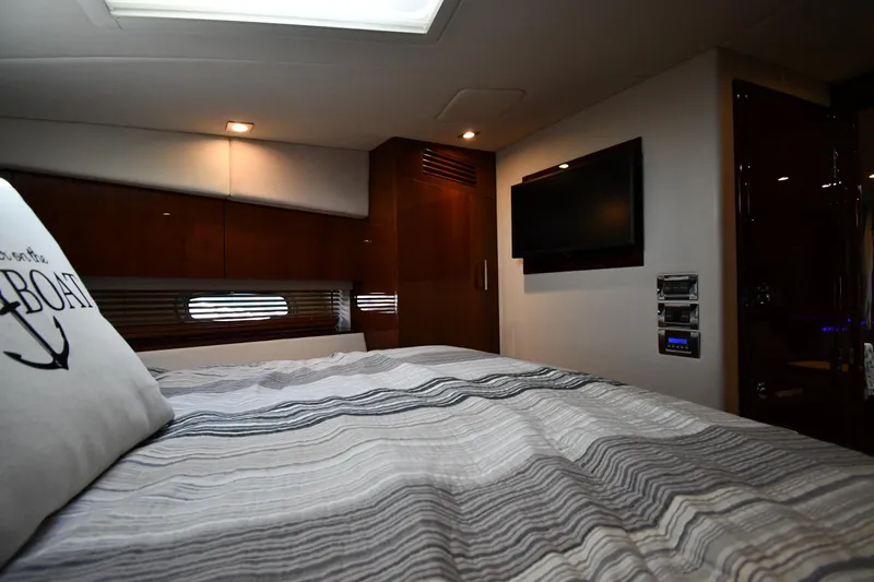 Land Shark Yacht Photos Pics Interior cabin of 2010 Sea Ray 450 Sundancer yacht with bed and wall-mounted TV.