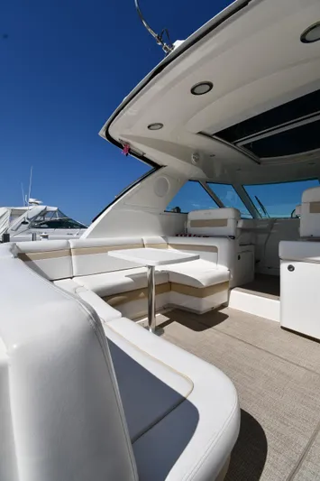 Land Shark Yacht Photos Pics 2010 Sea Ray 450 Sundancer yacht interior with white seating under clear blue sky.