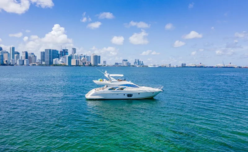  Yacht Photos Pics Azimut 55E yacht from 2005 cruising near a city skyline on a sunny day.