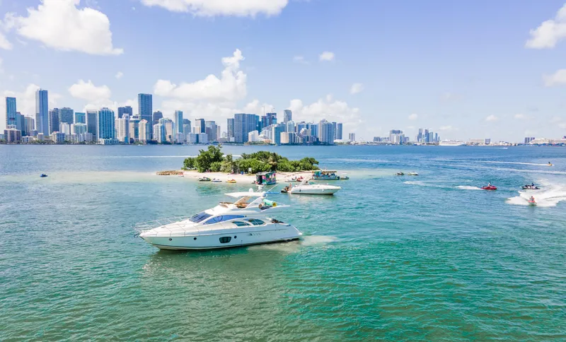  Yacht Photos Pics Azimut 55E yacht cruising near a small island with city skyline in the background.