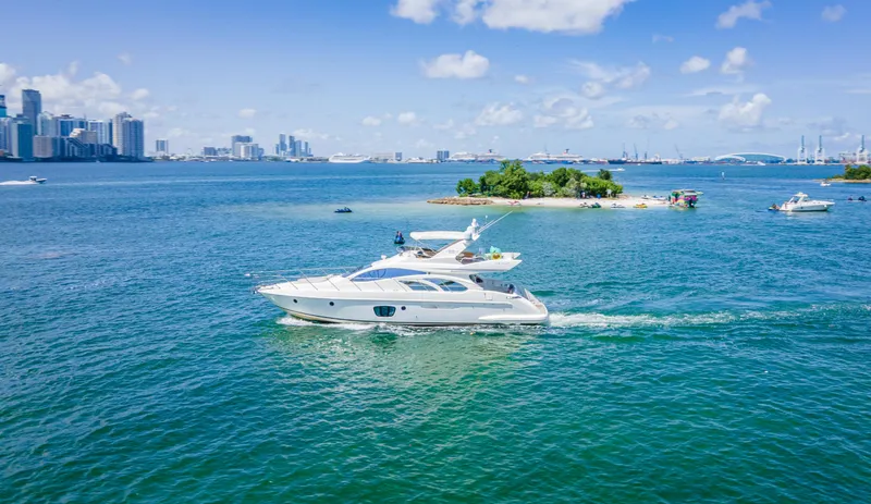  Yacht Photos Pics 2005 Azimut 55E yacht cruising near a small island with city skyline in the background.