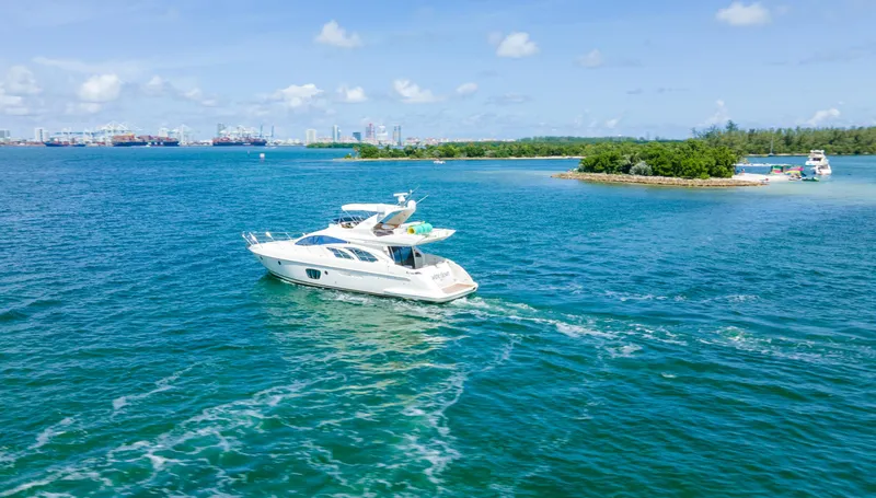  Yacht Photos Pics Azimut 55E yacht cruising on blue waters near a small island, 2005 model.