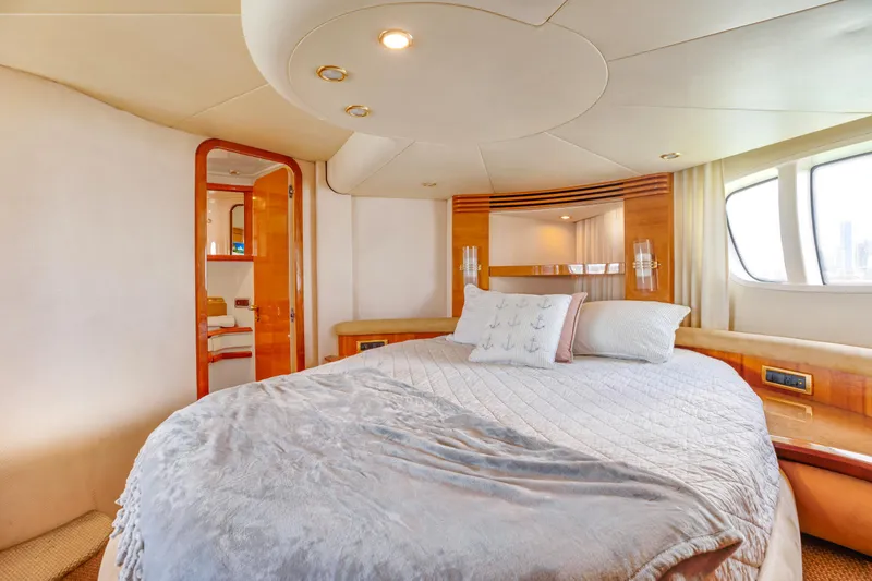  Yacht Photos Pics Luxurious bedroom interior of 2005 Azimut 55E yacht with cozy bedding and elegant design.