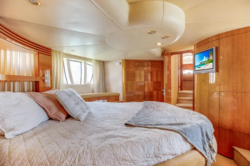  Yacht Photos Pics Luxurious bedroom interior of a 2005 Azimut 55E yacht with elegant wood finishes.