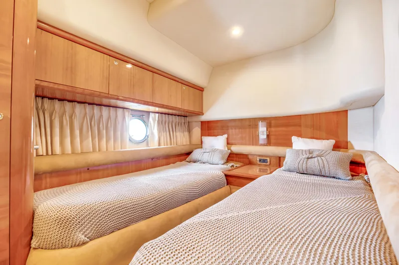  Yacht Photos Pics Luxurious twin cabin in 2005 Azimut 55E yacht, featuring elegant wood finishes and cozy bedding.